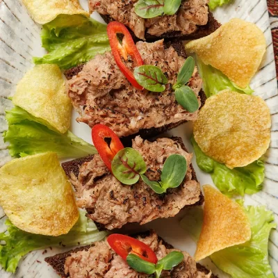 Белорусская закуска к пиву в виде бутербродов с фирменной копчёной рыбой (дикий толстолобик) и картофельными чипсами на жареном ржаном хлебе от Ресторана «Кухмистр»