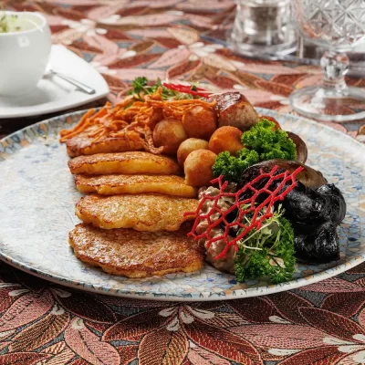 Дегустационный сет белорусских горячих закусок: три вида фирменных жареных колбас (свиная, печёночная и кровяная), жареные картофельные клёцки с соусом из грудинки, драники и сметана – от Ресторана «Кухмистр»