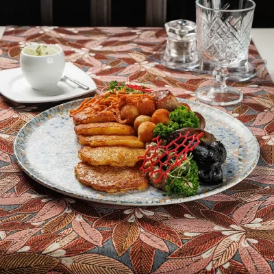 Дегустационный сет белорусских горячих закусок: три вида фирменных жареных колбас (свиная, печёночная и кровяная), жареные картофельные клёцки с соусом из грудинки, драники и сметана – от Ресторана «Кухмистр»