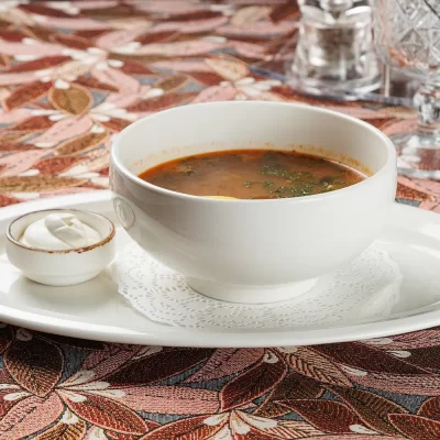 Домашняя солянка с фирменной бужениной, копчёной грудинкой, говядиной, а также с солёными огурцами, маслинами и лимоном от Ресторана «Кухмистр»