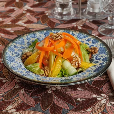 Витаминный салат «Бабушкин» из свежих сельдерея, яблока, перца, моркови, зелёного салата, грецких орехов, огурца и апельсина, заправленный лимонным соком и оливковым маслом от Ресторана «Кухмистр»